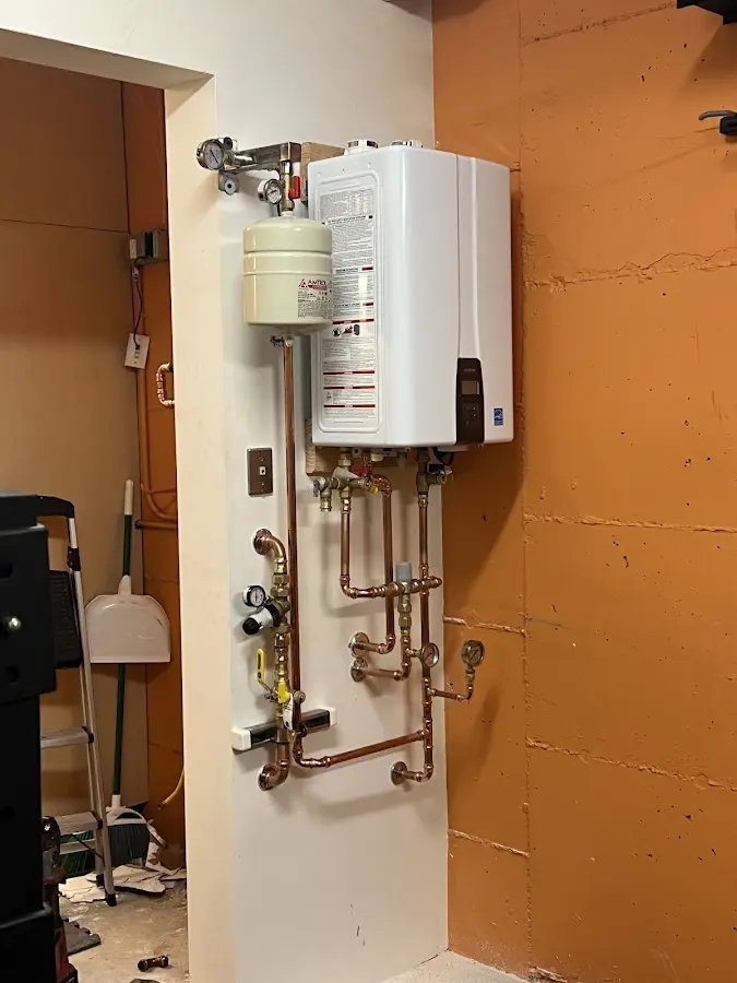 Plumbing technician inspecting water heater connections in Marbletown